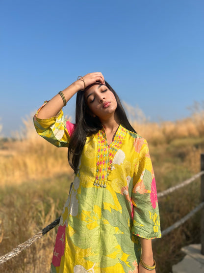 Model wearing a vibrant lime green flower gloss set in a natural outdoor setting, exuding effortless style.