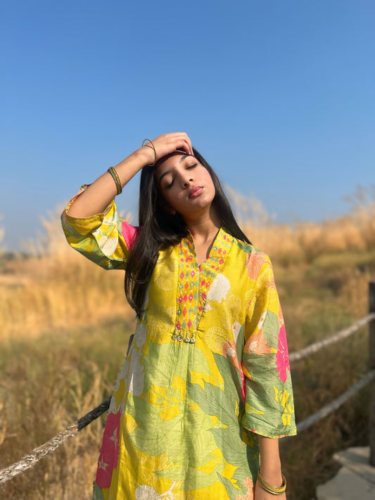 Model wearing a vibrant lime green flower gloss set in a natural outdoor setting, exuding effortless style.
